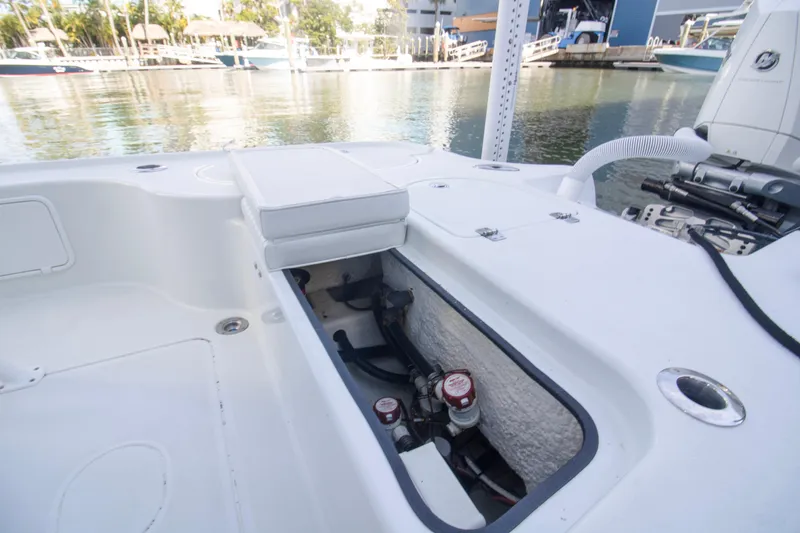 Slide: The Image of 2014 Yellowfin 24 Bay boat interior with open storage compartment, docked by the water. - 3