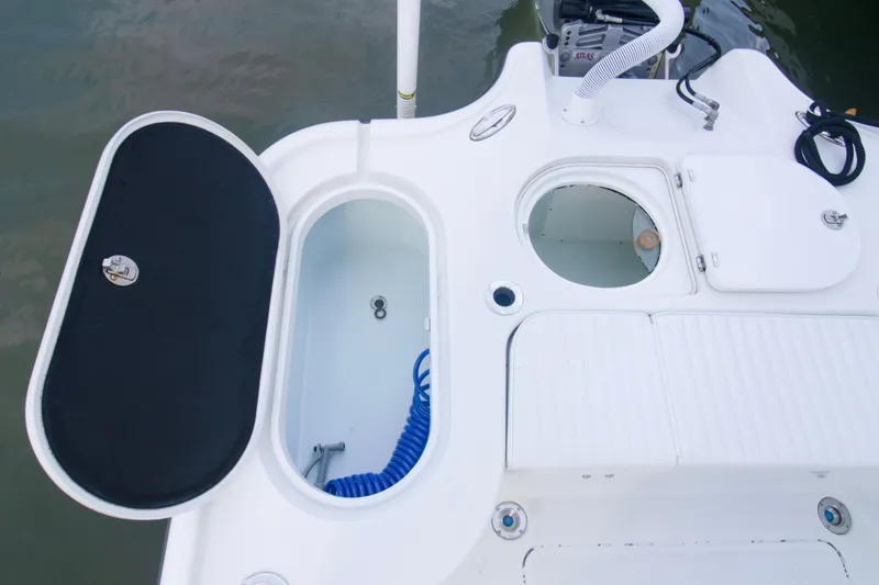 Slide: The Image of 2014 Yellowfin 24 Bay boat deck with storage compartments and hose. - 4