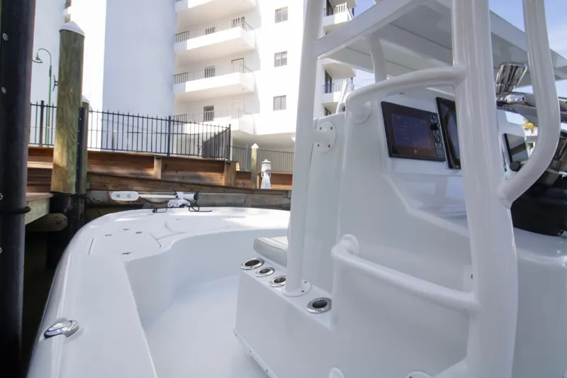 Slide: The Image of 2014 Yellowfin 24 Bay boat docked near a building, showcasing its sleek design. - 6