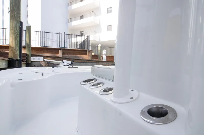 Slide: The Image of 2014 Yellowfin 24 Bay boat interior with rod holders, docked near a building. - 8