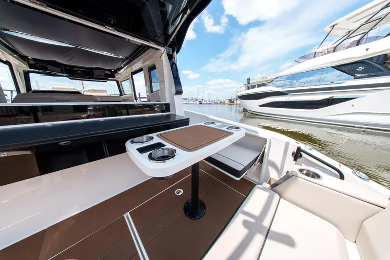 Slide: The Image of Modern Navan C30 boat interior with table, cup holders, and seating, docked near other yachts. - 17