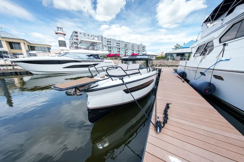 Slide: The Image of 2026 Navan C30 boat docked at marina with lighthouse and buildings in background. - 8