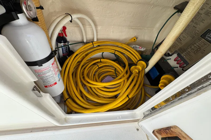 Slide: The Image of Storage compartment of 2003 Riviera Cruiser M470 Excalibur with yellow cables and fire extinguisher. - 16