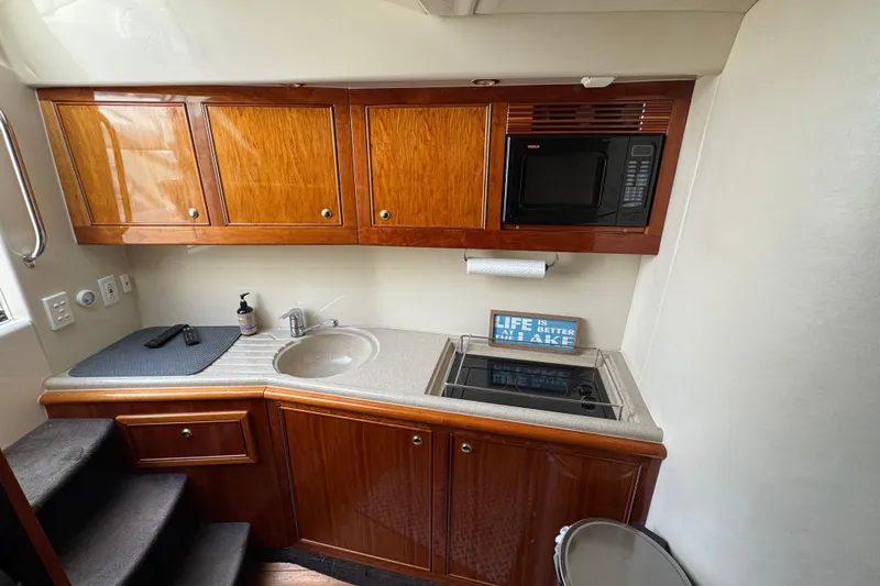 Slide: The Image of 2003 Riviera Cruiser M470 Excalibur kitchen with wooden cabinets, sink, and microwave. - 37