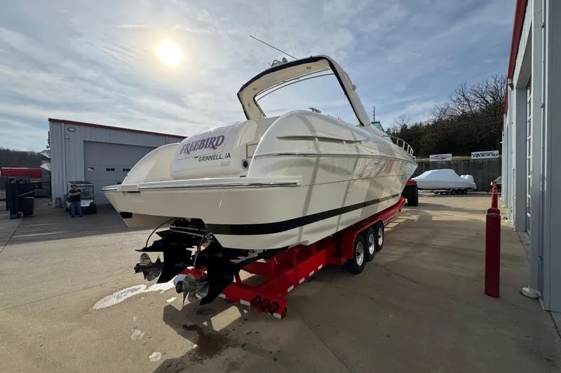 Slide: The Image of 2003 Riviera Cruiser M470 Excalibur boat on red trailer in sunny outdoor setting. - 4