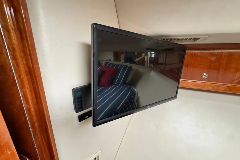 Slide: The Image of Flat-screen TV in 2003 Riviera Cruiser M470 Excalibur cabin, with wood paneling and striped bedding. - 42