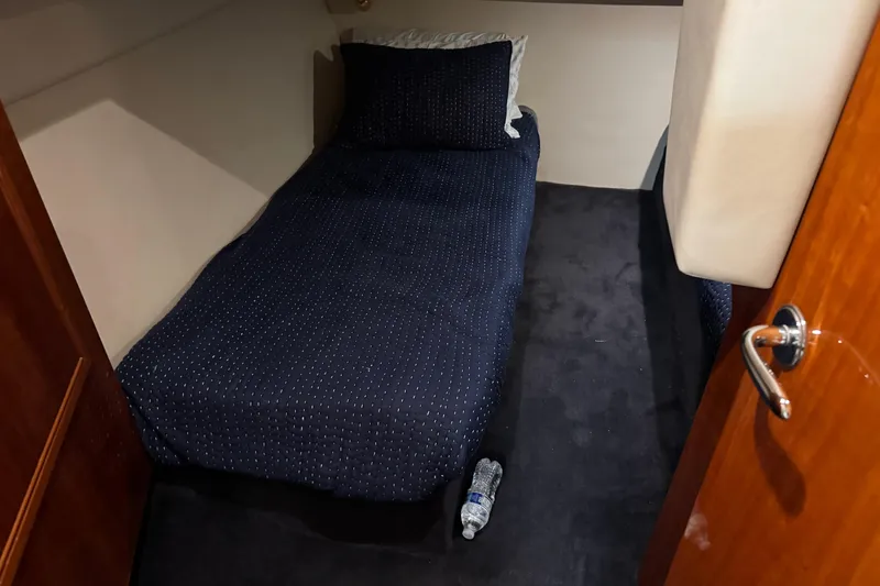 Slide: The Image of Small cabin interior of 2003 Riviera Cruiser M470 Excalibur with single bed and water bottle. - 47