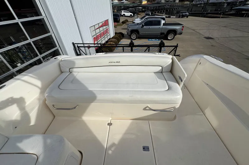 Slide: The Image of 2003 Riviera Cruiser M470 Excalibur boat with white seating area, parked near a dealership. - 9