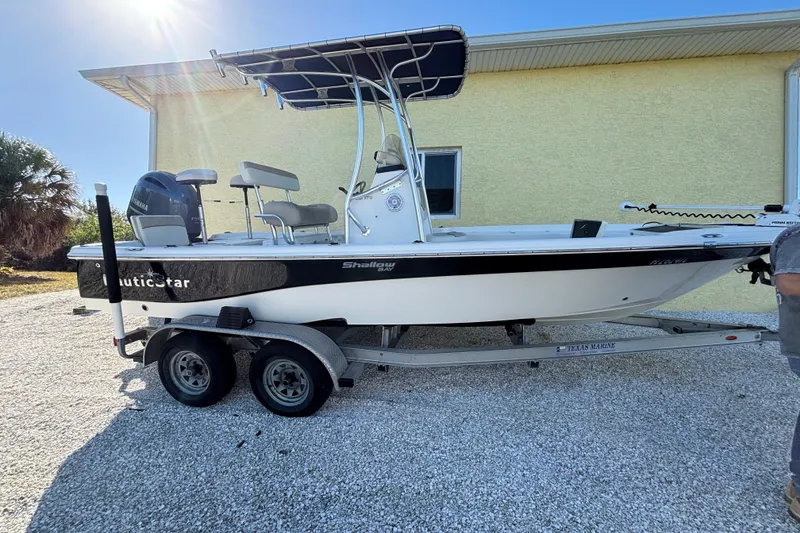 The Image of 2017 NauticStar 215 XTS Shallow Bay boat on trailer, parked outdoors. - 0