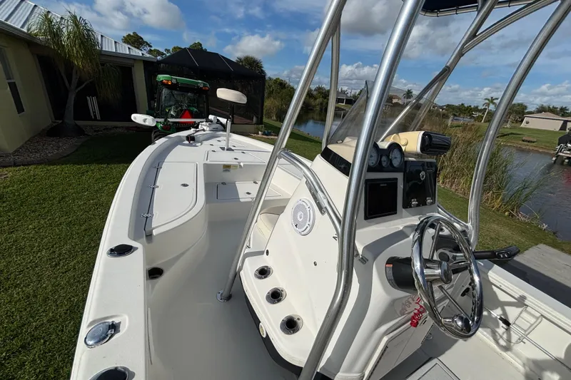 Slide: The Image of 2017 NauticStar 215 XTS Shallow Bay boat with steering console, docked near a house. - 12