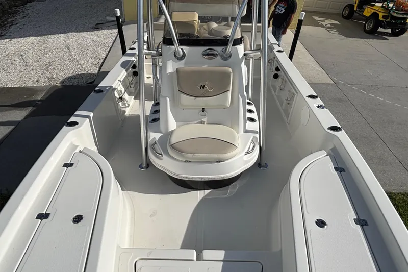 Slide: The Image of 2017 NauticStar 215 XTS Shallow Bay boat interior with seating and storage compartments. - 15