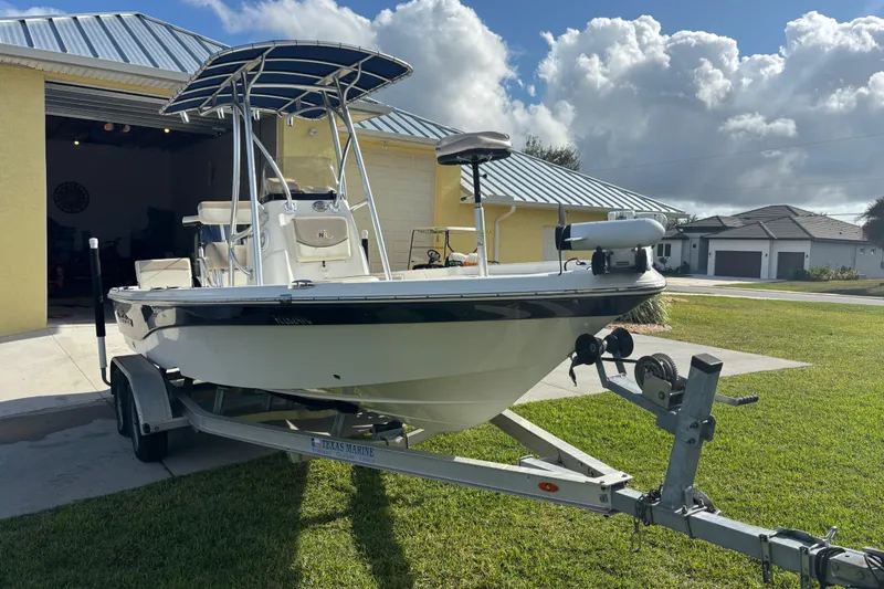 Slide: The Image of 2017 NauticStar 215 XTS Shallow Bay boat on trailer in driveway. - 4