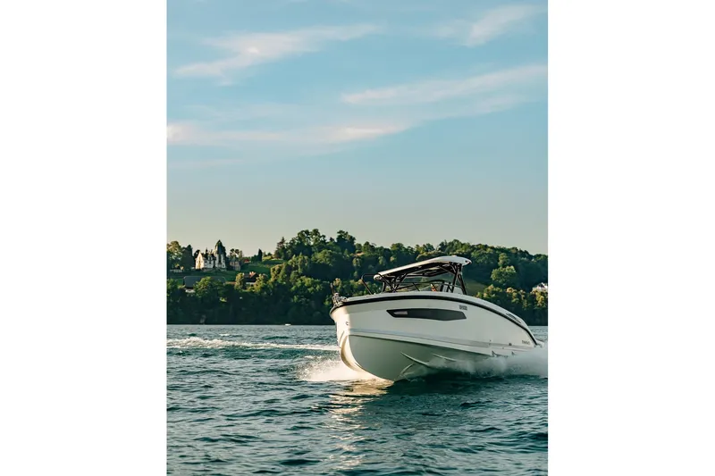 Slide: The Image of Navan S30 2026 boat cruising on a scenic lake with lush greenery. - 12