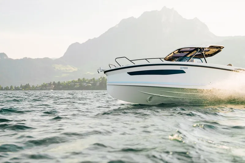 Slide: The Image of 2026 Navan S30 boat cruising on a scenic lake with mountains in the background. - 13