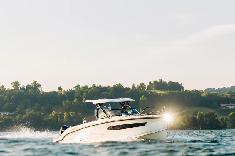 Slide: The Image of 2026 Navan S30 boat cruising on a scenic lake with lush green hills. - 14