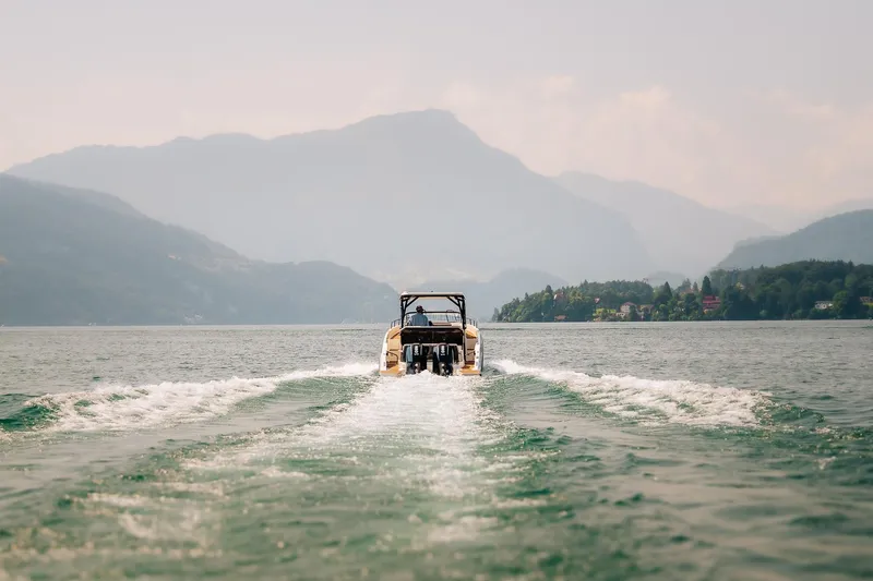 Slide: The Image of Navan S30 boat cruising on a serene lake with mountainous backdrop, 2026 model. - 24