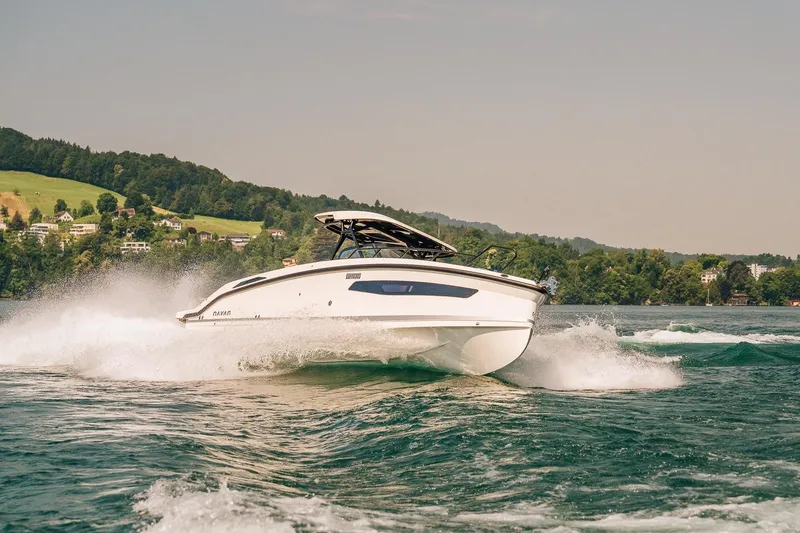 Slide: The Image of Navan S30 2026 boat cruising on a scenic lake with lush green hills. - 25