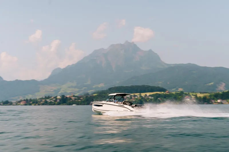 Slide: The Image of Navan S30 boat cruising on a scenic lake with mountains in the background, 2026 model. - 32