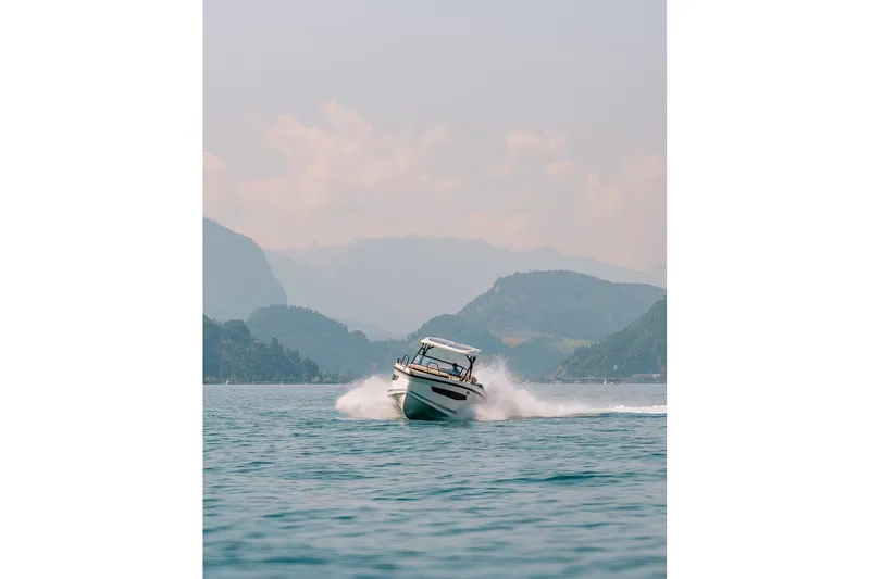 Slide: The Image of Navan S30 boat cruising on a scenic lake with mountainous backdrop, 2026 model. - 33