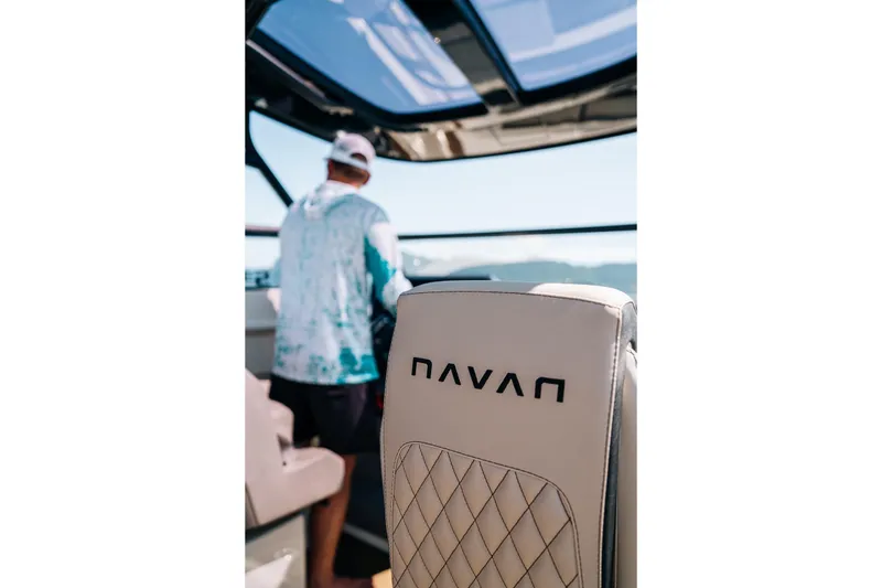 Slide: The Image of 2026 Navan S30 boat interior with logo on seat, person steering in background. - 39