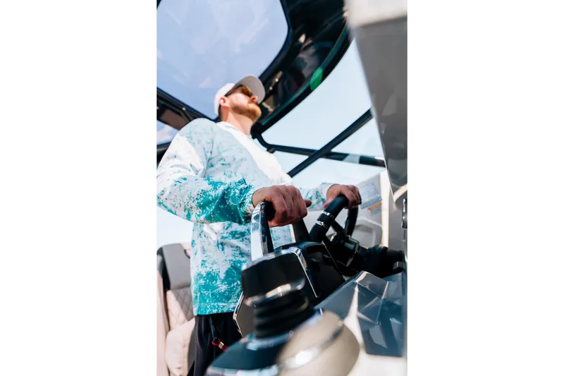 Slide: The Image of Person steering 2026 Navan S30 boat, wearing a blue patterned shirt and cap. - 41