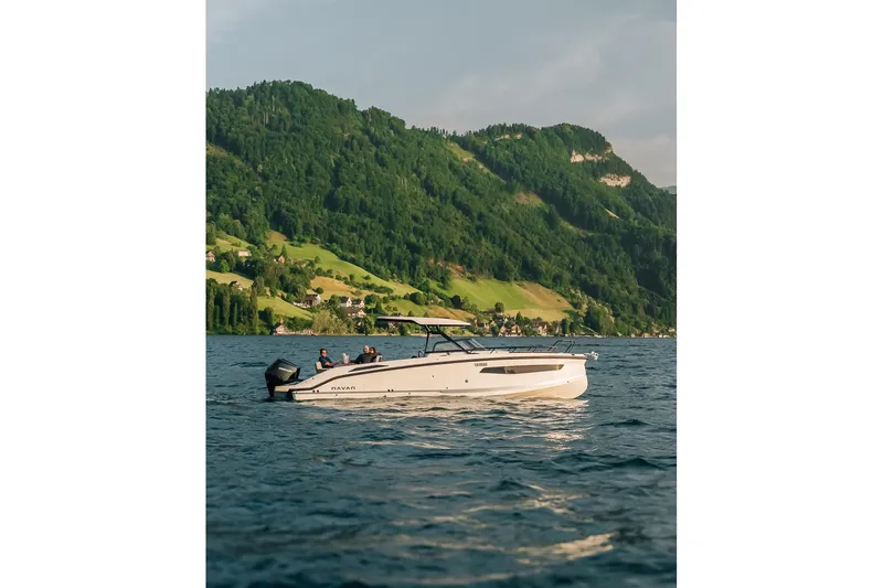 Slide: The Image of Navan S30 boat cruising on a scenic lake with lush green hills, 2026 model. - 43