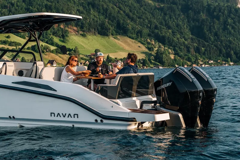 Slide: The Image of Navan S30 boat on a lake, people dining onboard, scenic mountain backdrop, 2026 model. - 44