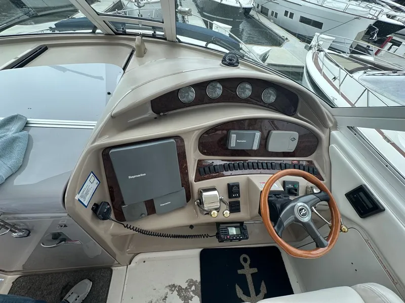 Slide: The Image of 2004 Sea Ray 390 Motor Yacht helm with wood accents and modern navigation equipment. - 10