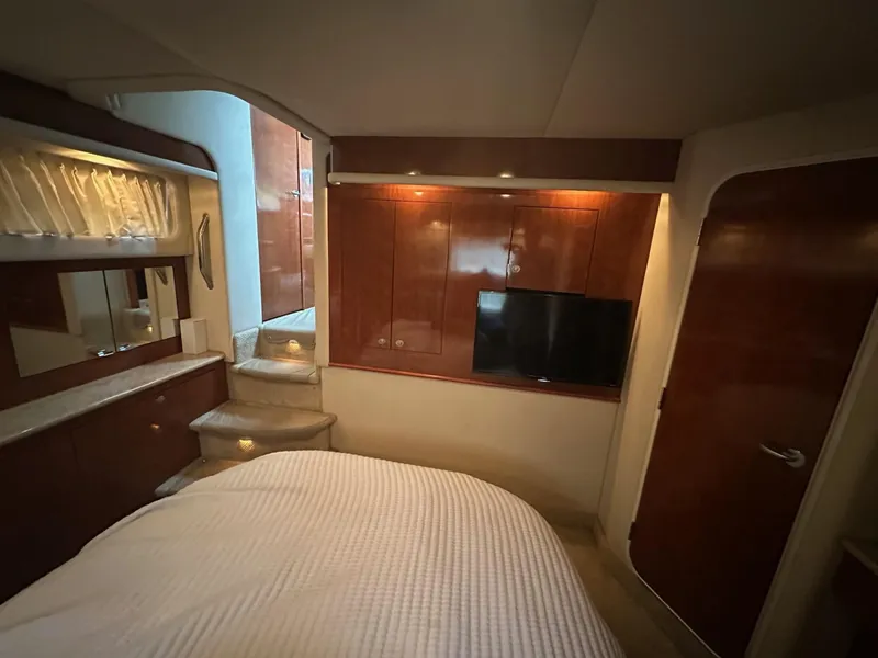 Slide: The Image of Luxurious interior of 2004 Sea Ray 390 Motor Yacht with wood cabinetry and cozy bedding. - 11