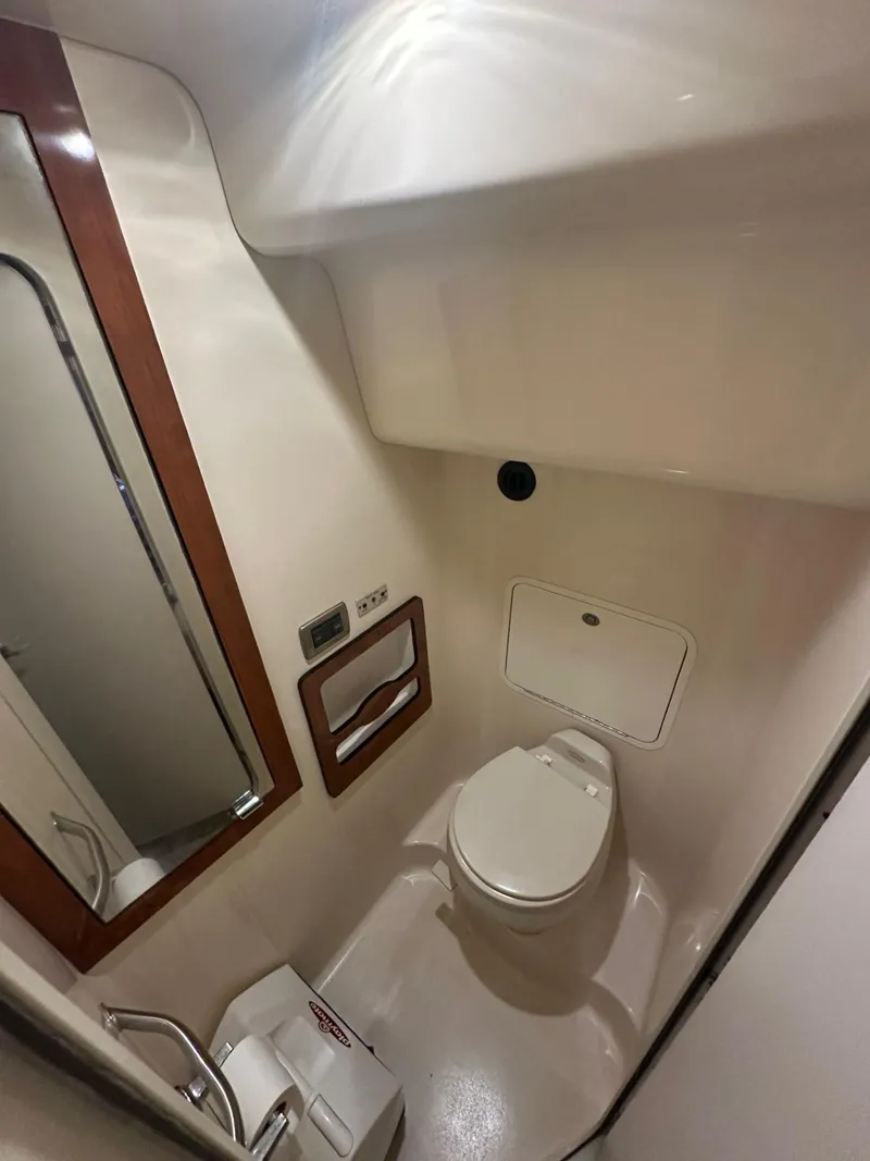 Slide: The Image of 2004 Sea Ray 390 Motor Yacht bathroom with toilet, mirror, and storage. - 14