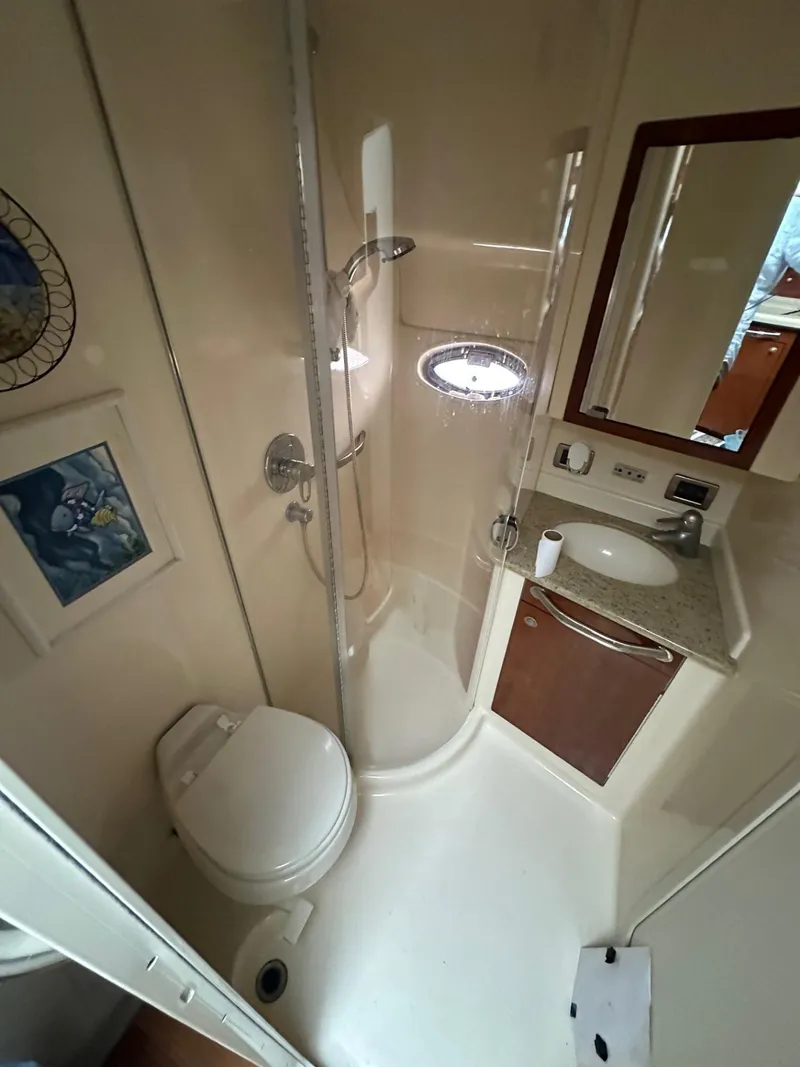 Slide: The Image of 2004 Sea Ray 390 Motor Yacht bathroom with shower, toilet, sink, and mirror. - 15