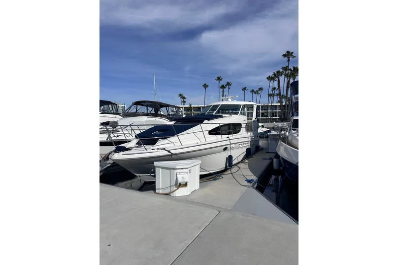 Slide: The Image of 2004 Sea Ray 390 Motor Yacht docked at marina under clear blue sky. - 2