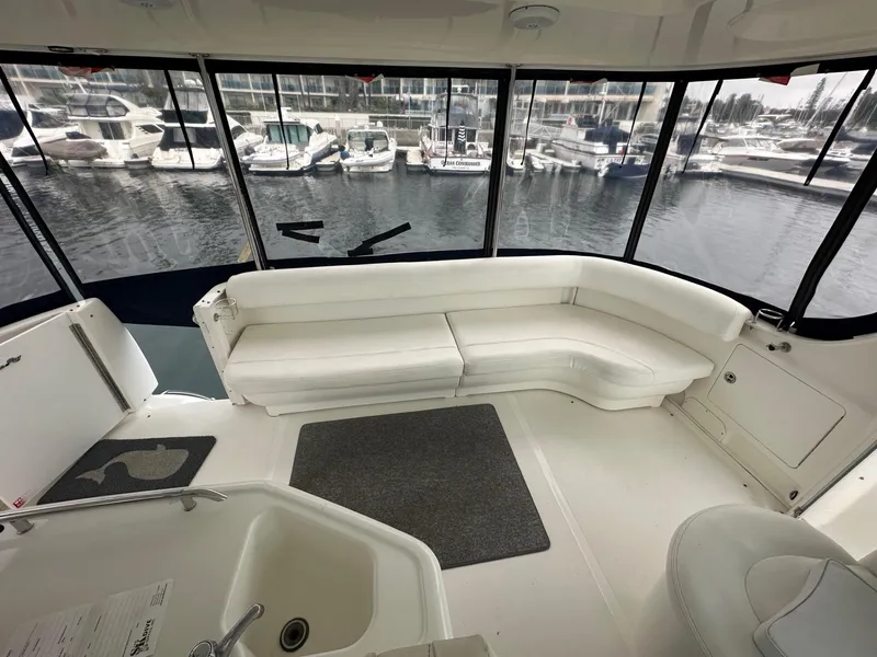 Slide: The Image of 2004 Sea Ray 390 Motor Yacht interior with white seating and marina view. - 5