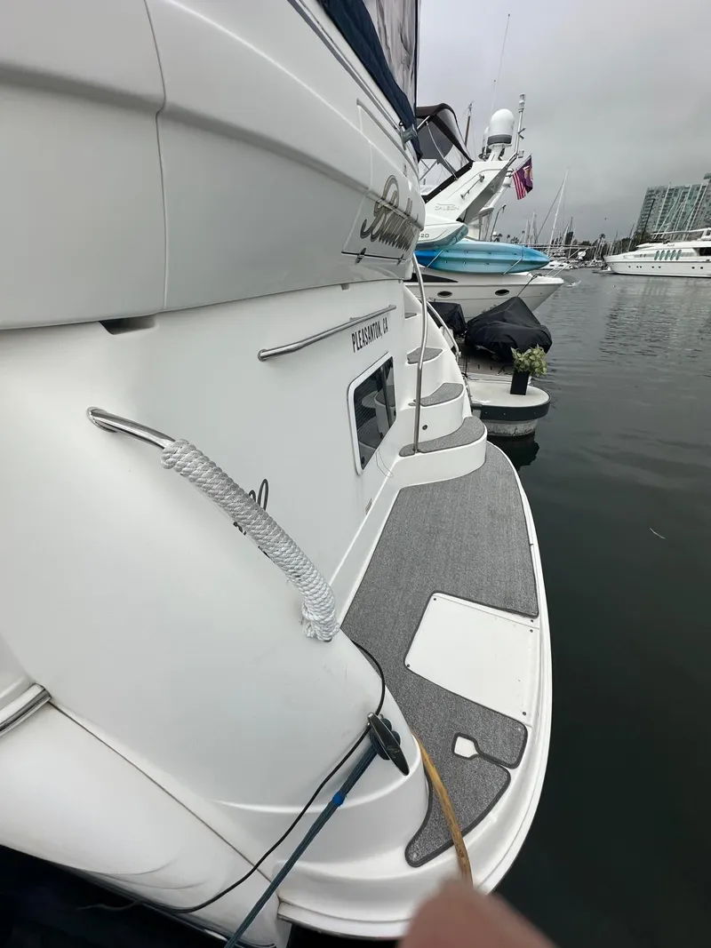 Slide: The Image of 2004 Sea Ray 390 Motor Yacht docked, showcasing sleek design and spacious deck. - 7