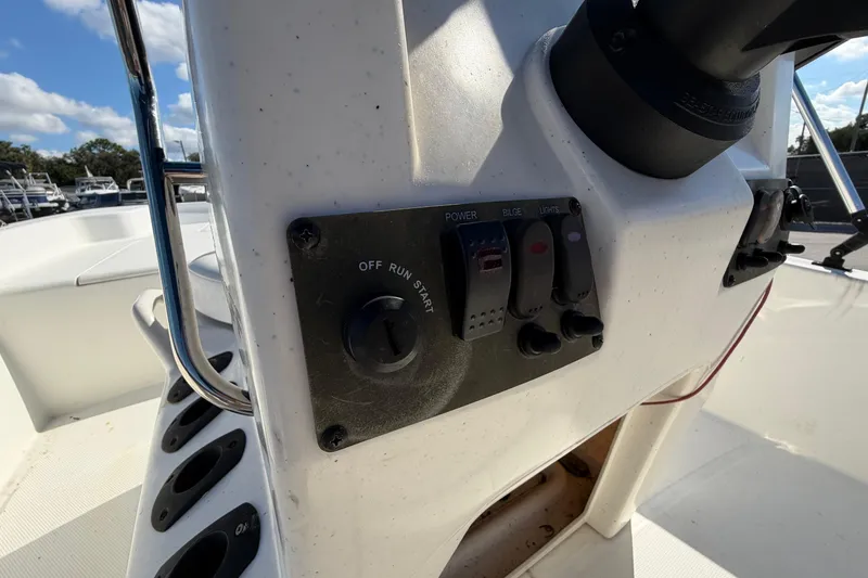 Slide: The Image of 2019 Mako Pro Skiff 15 CC with blue canopy, parked outdoors. - 14