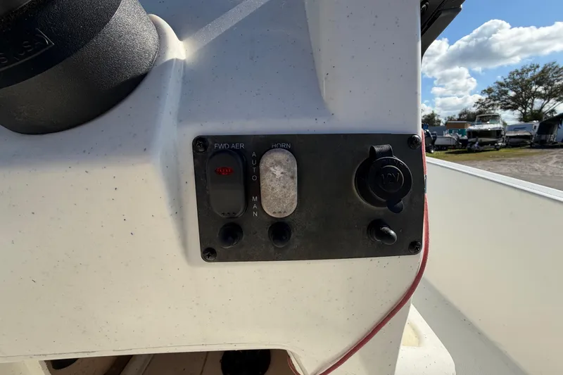 Slide: The Image of 2019 Mako Pro Skiff 15 CC with blue canopy in a boat dealership lot. - 15