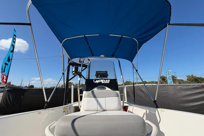 Slide: The Image of 2019 Mako Pro Skiff 15 CC boat deck with trolling motor, parked on pavement. - 25