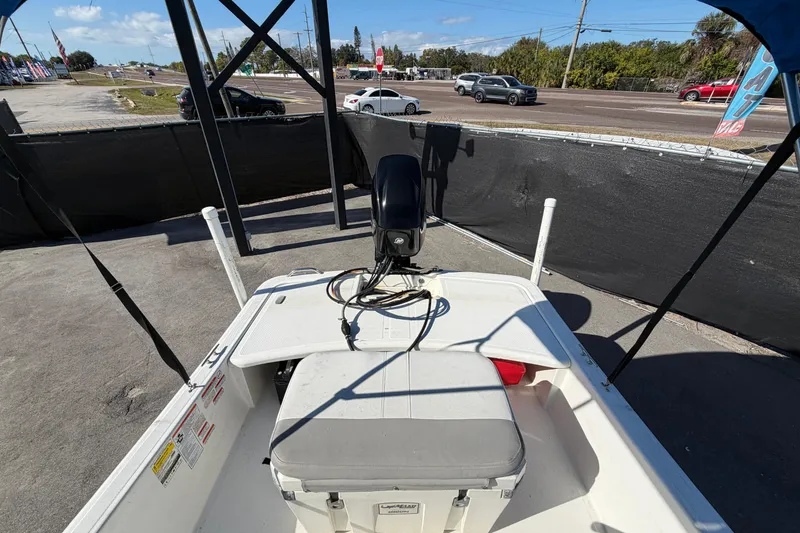 Slide: The Image of Open storage compartment of 2019 Mako Pro Skiff 15 CC with battery and orange case. - 29