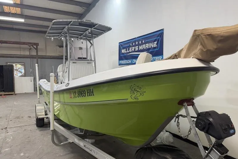 Slide: The Image of 2023 Panga 22 SPORT boat in a garage, lime green hull, on a trailer. - 3