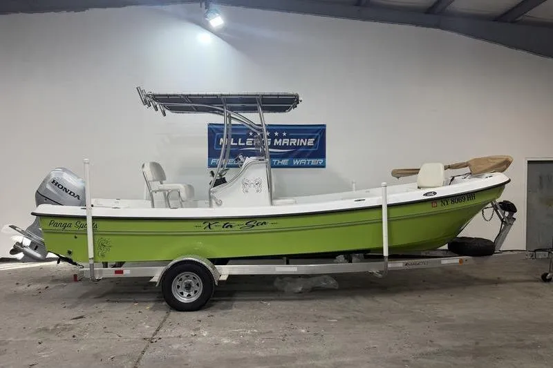 Slide: The Image of 2023 Panga 22 SPORT boat on trailer, lime green hull, indoor display. - 1
