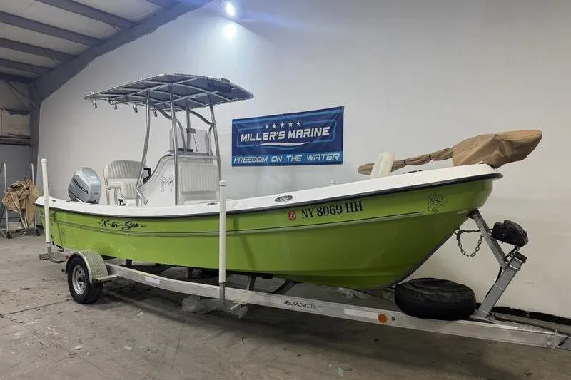 Slide: The Image of 2023 Panga 22 SPORT boat in a showroom, lime green hull, on a trailer. - 2