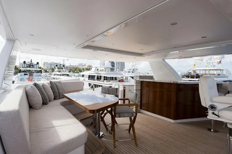 Slide: The Image of Luxurious 2018 Westport Raised Pilothouse yacht deck with seating and sunshade, overlooking serene waters. - 48
