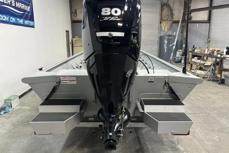 Slide: The Image of 2025 SeaArk 1860 MVJT boat with 80 HP motor in a workshop setting. - 5