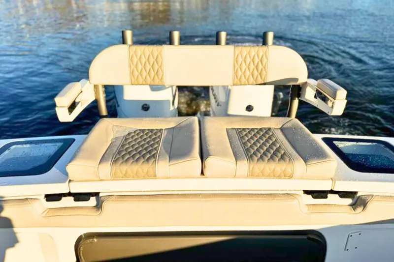 Slide: The Image of 2023 Solace 32 CS boat with open storage compartment, on calm blue water. - 17