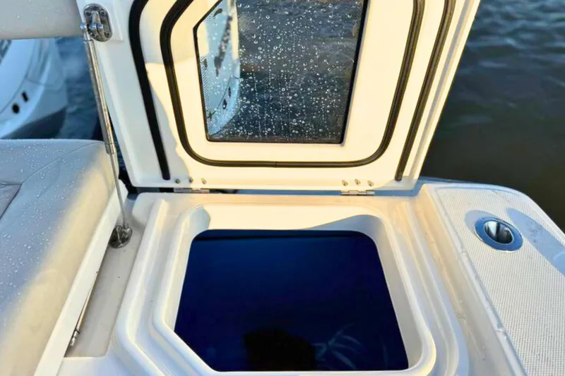 Slide: The Image of 2023 Solace 32 CS boat interior with seating and storage, featuring a Frigid Rigid cooler. - 22