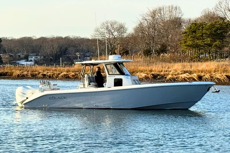 Slide: The Image of 2023 Solace 32 CS boat cruising on open water under a clear sky. - 4