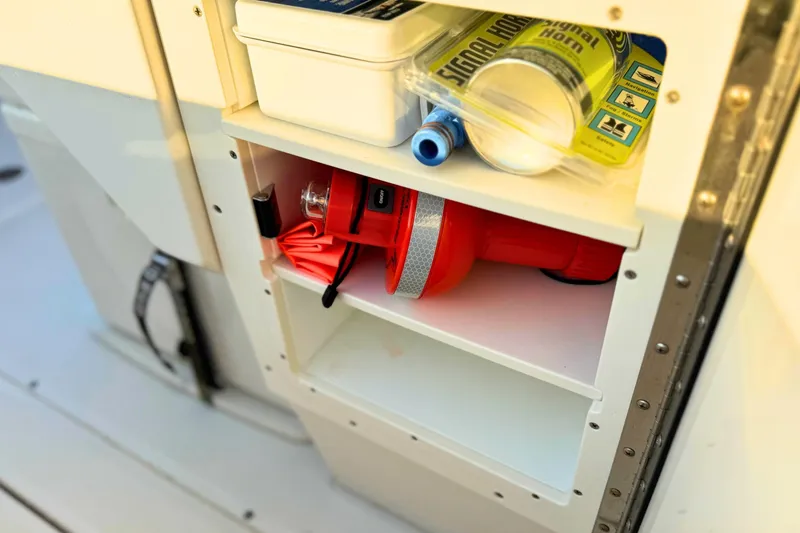 Slide: The Image of Open storage compartment on 2023 Solace 32 CS boat, featuring three shelves. - 47