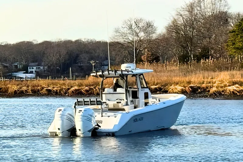 Slide: The Image of 2023 Solace 32 CS boat cruising on open ocean under clear blue sky. - 5