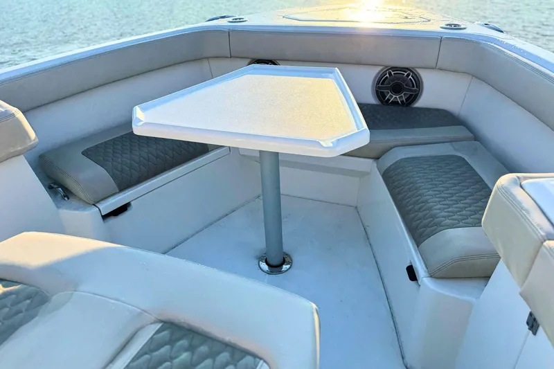 Slide: The Image of 2023 Solace 32 CS boat interior with beige seating, docked on calm water. - 59