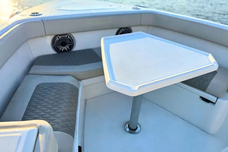 Slide: The Image of 2023 Solace 32 CS boat storage compartment, open and empty, with cushioned seating. - 60